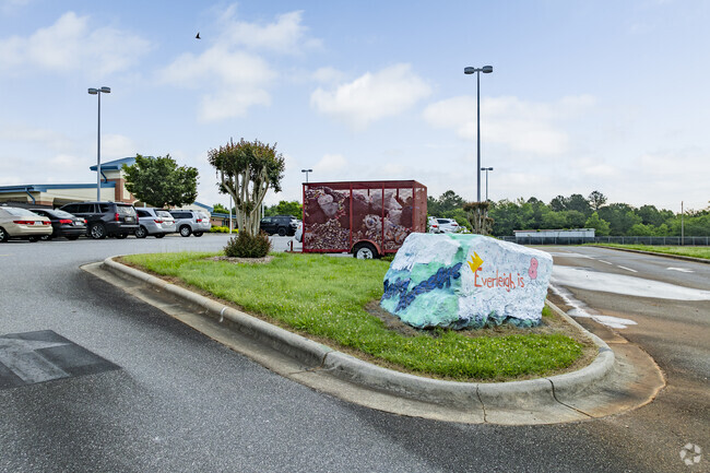 Students of Charles H. Tuttle Middle School help to keep the school boulder decorated.