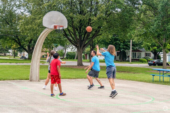 Friends enjoy a game of basketball game at Marquette Park near Olde Norwood.
