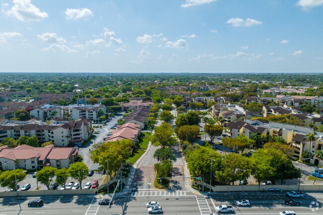 The main entrance to Kenland along Kendall Drive welcomes residents with palm trees and well-kept grounds.