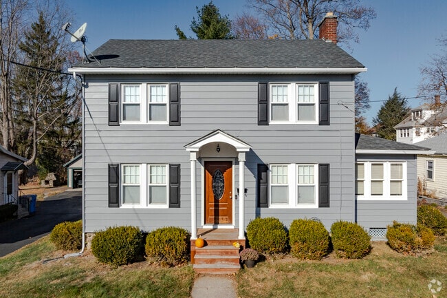 A main street colonial in North Bristol with a bright wooden door.