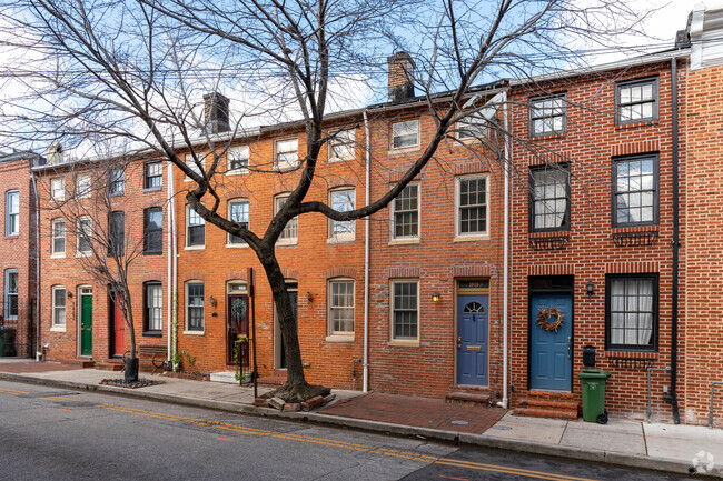 A row of brick homes in Fells Point on display in the winter, with only street parking.
