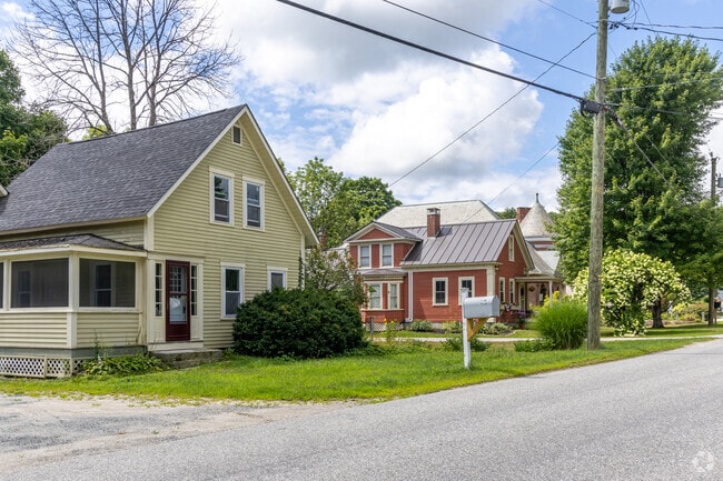 A row of New England farmhouse-style homes in Sutton, New Hampshire.