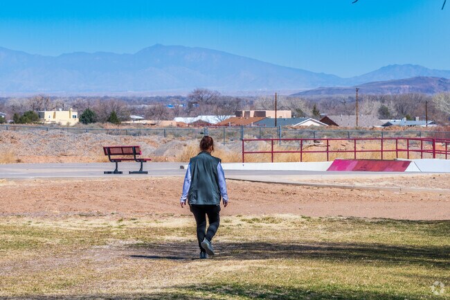 A woman enjoys a walk around Eagle Park on a beautiful day with the skate park visible.