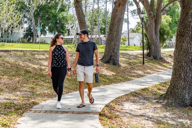 A couple enjoys a stroll in Lake David Park near Mascotte.