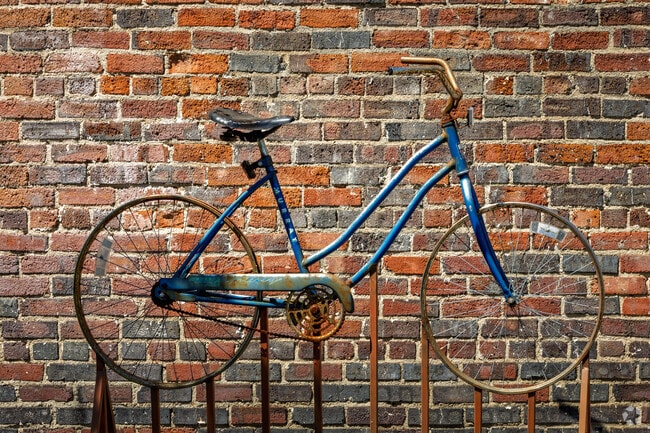 A vintage bike sculpture adds character to a historic brick wall in downtown Liberty.