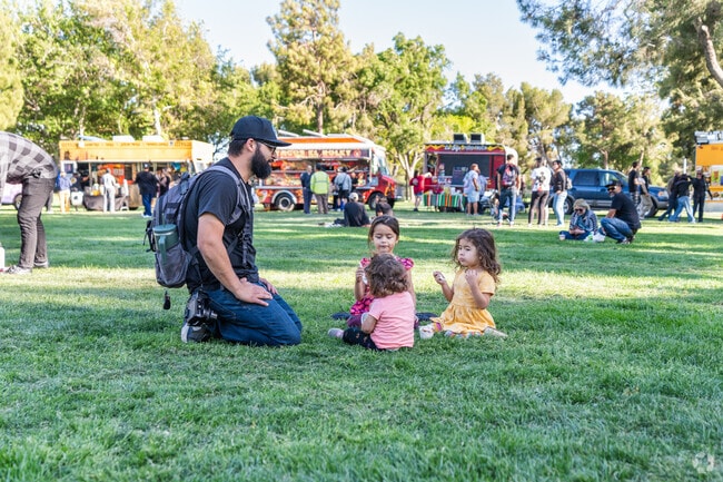 A father and his girls enjoy a snack on the grass at Monday Night Bites.