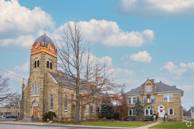 A majestic stone church with bright orange details on the corner in downtown Grafton