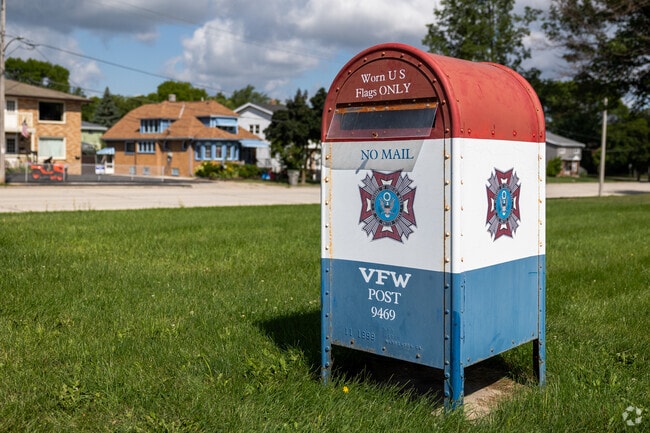 A red, white, and blue drop-off bin for worn American flags in Mitchell West.