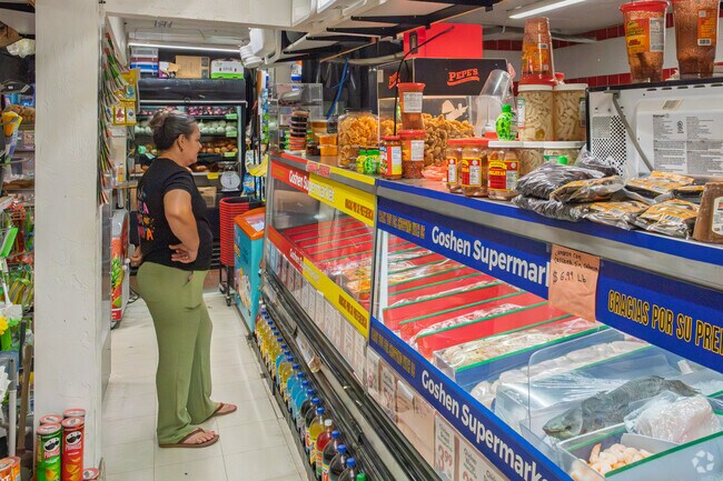 A resident takes time to decide what meat she needs at Goshen Super Market.