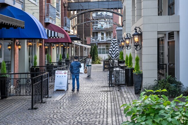 A couple of tourists snapping photos outside shops in Wine Alley in Cottage Lake.