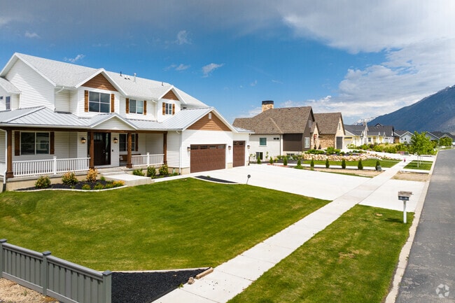 A row of large homes in Mapleton presents an impressive streetscape, showcasing elegant architecture, manicured lawns, and a sense of grandeur.