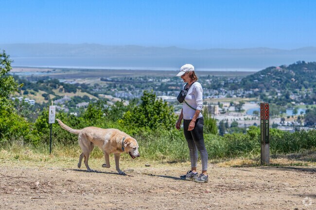 A lady calls her dog over so she can get started on her hike through Sorich Park.