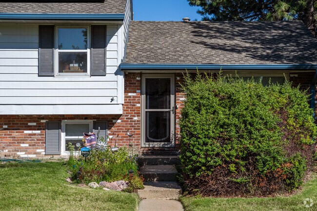 A split level home with lush vegetation and brick detailing in Parkway Estates, Arvada, Colorado