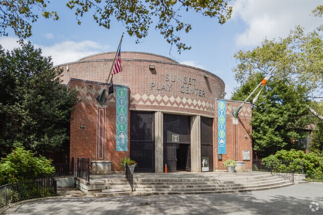Sunset Park is a lush expense of green with a swimming pool.