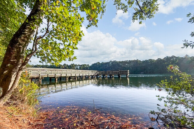 A fishing pier extends over Sandy Bottom Lake at Hampton’s nature park.