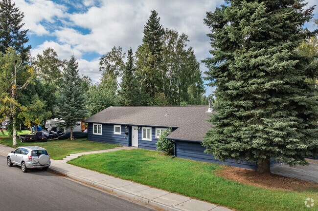 A tree-lined street with a ranch-style home in Weeks Field.