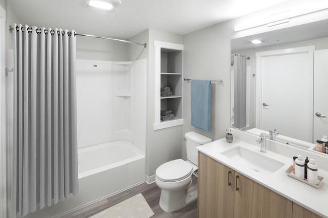 Phase II - Scheme D Bath with oak cabinetry, white quartz countertop, and hard surface flooring