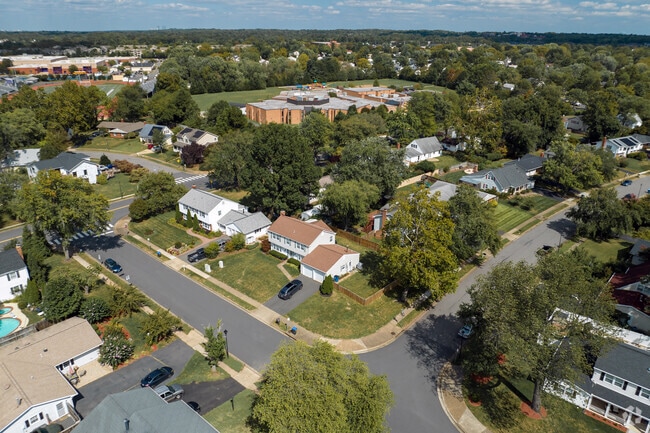 Greenbriar homes are nestled among a wooded landscape with shady trees along the streets.