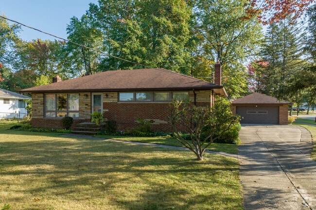 Brick Ranch style home with a tidy lawn in Seven Hills.