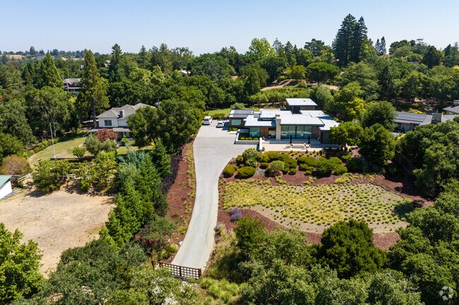 Modern homes with long driveways sit atop the hills of Woodside, CA.