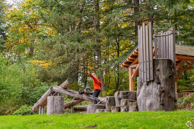 Children climb on the natural jungle gym at Bull Mountain Park.
