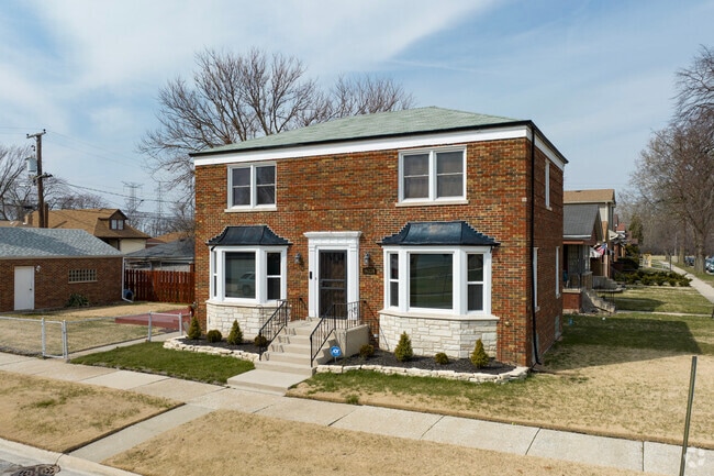 Large brick Gedorgian homes with bay windows sit on well manicured lots.