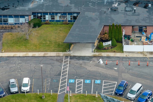 Modern buildings, lush surroundings in Sage School's aerial perspective.