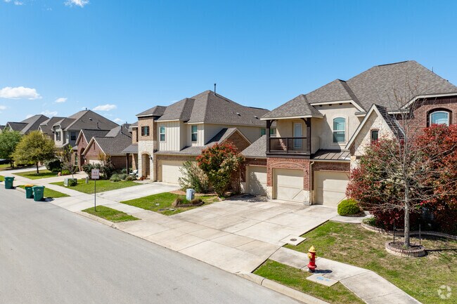 A street lined lined with two-story national and traditional homes in Boerne, Texas.