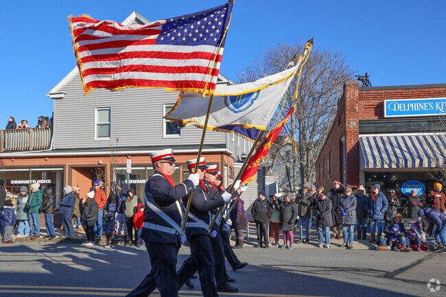 Flags flutter in the air as the festive Beverly Holiday Parade marches proudly down Cabot Street.