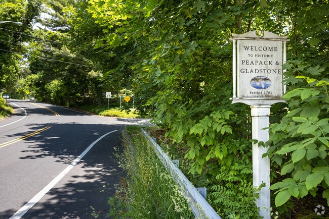 A roadside sign welcomes you to Peapack-Gladstone, NJ, settled in 1701 and incorporated in 1912.