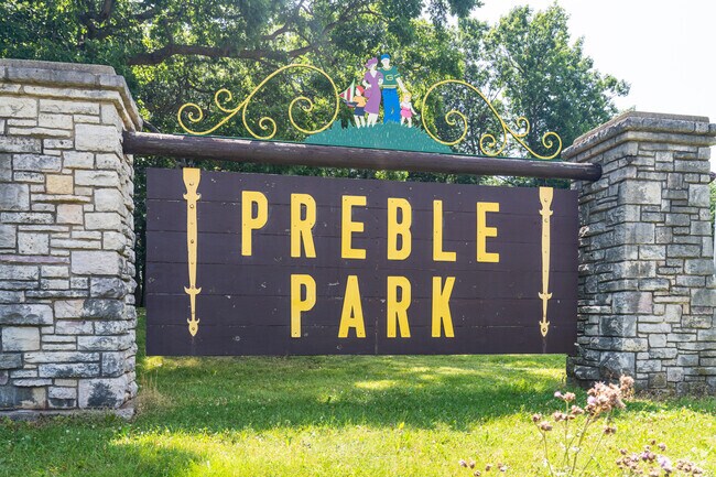 Preble Park has a well maintained playground covered in deep shade  from towering trees.