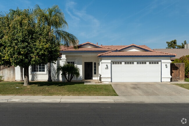 This single-story home in Tyner Ranch features white stucco and Spanish tiled roof.