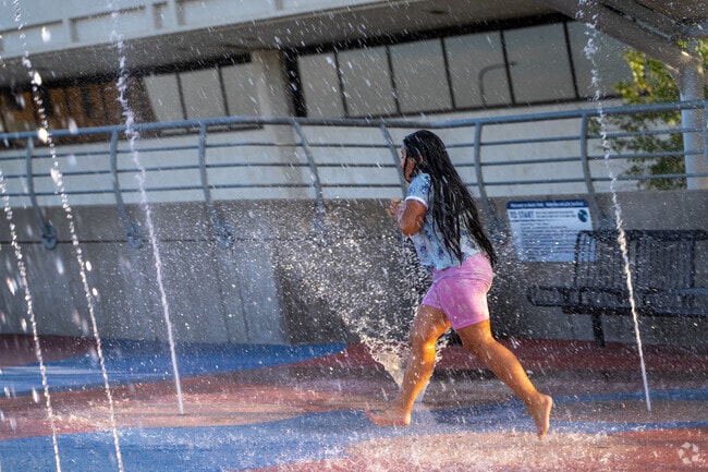 Kids from Liberty Park enjoy cooling off at the Waterloo splash park near the amphitheater.