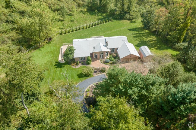 This tan, brick home in Sewickley Hills sits on a very secluded lot surrounded by talls trees.