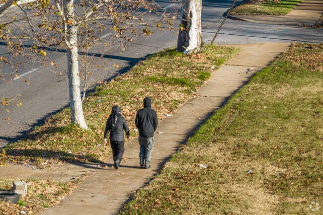 A couple walks along the sidewalk in Kingsway, MO.
