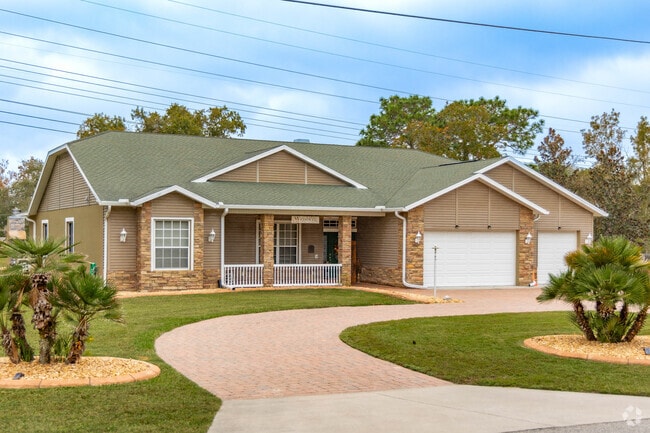 This home in Shady Hills features stone siding and a circle driveway.