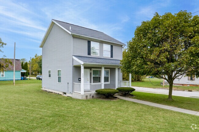 A manicured tree and large lawn graces this contemporary farmhouse in ONYX.