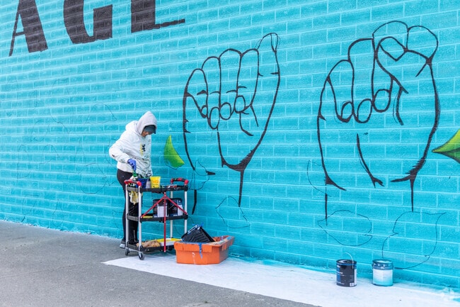 An artist paints a beautiful mural in West Side Sioux City.