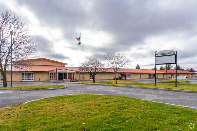 The Continuous Curriculum school features a student drop off loop in front of the school.