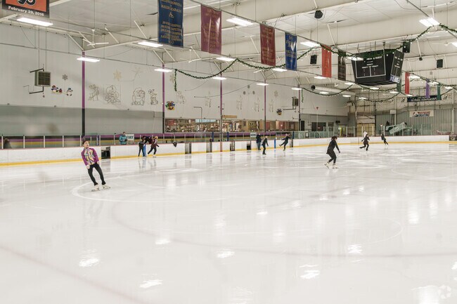 Young figure skaters warm up under the watchful eye of their coach at IceWorks in Chester Township.
