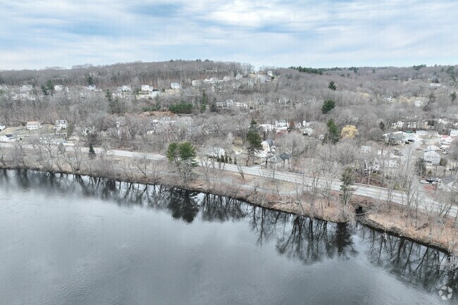 The scenic Merrimack River gracefully meanders near the established neighborhood of Bradley Brook.