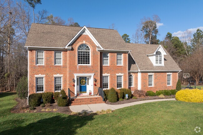 A large Colonial Revival in Tarrington with a bold brick face sits on a large green yard.