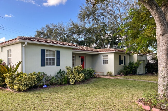 Many residential homes have stone shingle roofs and large yards.