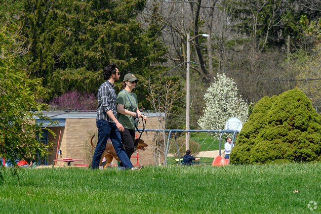 A couple walks their dog in Liberty Glen's Burr Oak Park.