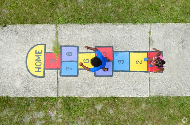 Children in University Park play hop-scotch at Victory Park.