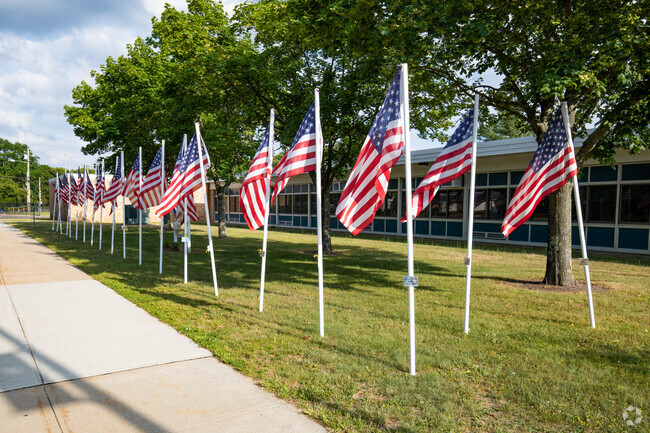 American flags wave on the front lawn of Seneca Middle School.