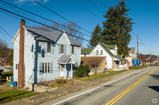 A farmhouse and a bungalow sit side-by-side along this New Stanton street.