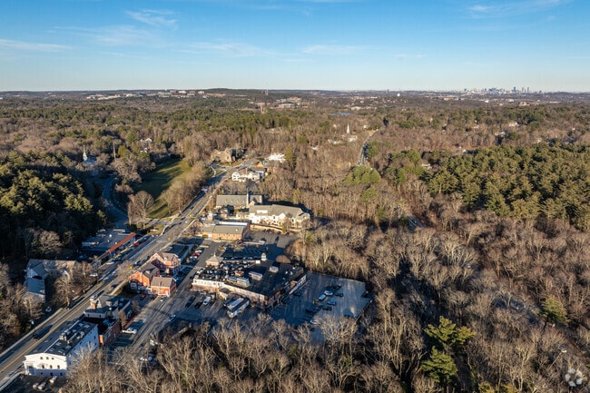 An aerial overview of Weston, MA in the late afternoon with the Boston skyline in the distance.