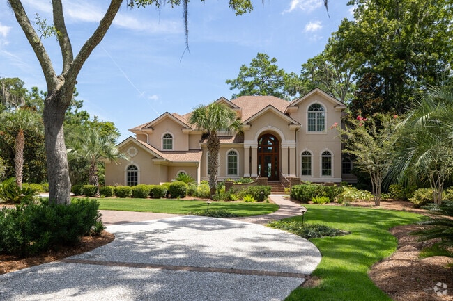 This home has a lovely manicured lawn and trees.