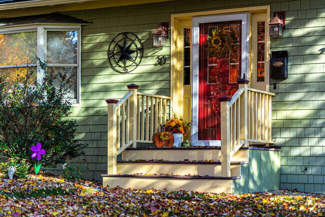 Front porches of Indian Hill homes are shaded by large trees.